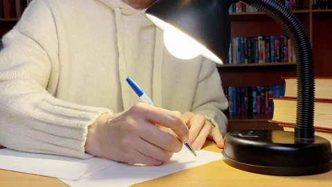 Middle-aged hands writing letter in library near lamp. Stock Footage 183794288