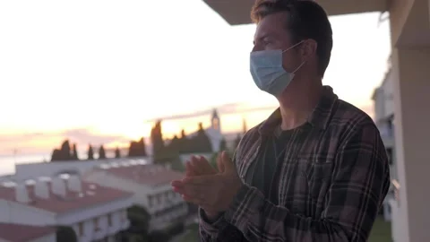 Middle aged handsome man on lockdown with medical mask clapping aplause on Stock Footage 143964306