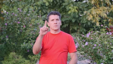Middle aged handsome man in red t-shirt say NO and disliking offer Stock Footage 112756985