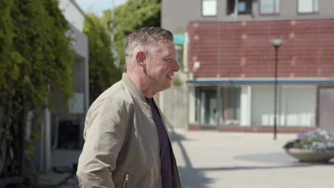 A middle-aged handsome man talking on a square. 库存影片 132556822