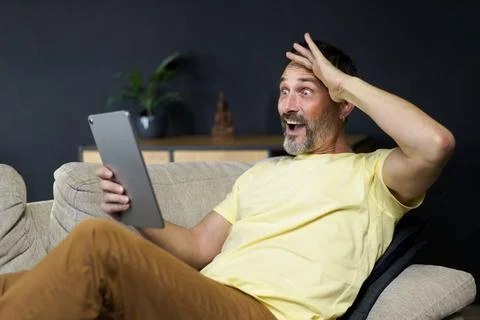 Middle aged handsome man use digital tablet to communicate via video call or Stock-Fotos