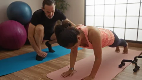 Middle-aged hispanic couple exercising indoors with fitness mats and balanc.. Stock Footage 304950720