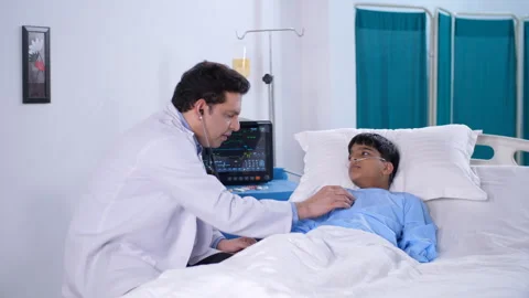 A middle-aged Indian doctor is using a stethoscope to listen to the heartbeat... Video stock 248813952