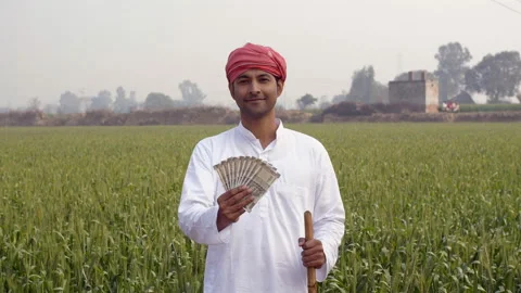 The middle-aged Indian farmer is smiling while showing his monthly income Video stock 134856957