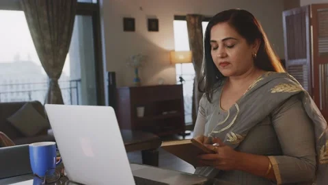 Middle-aged Indian Female shuts off laptop after finishing remote work from home Stock Footage