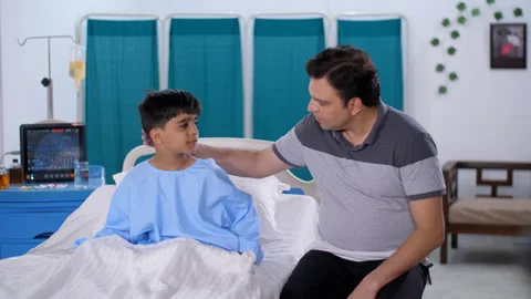 A middle-aged Indian man with his sick son in the hospital - father son bondi... Stock Footage 248814448
