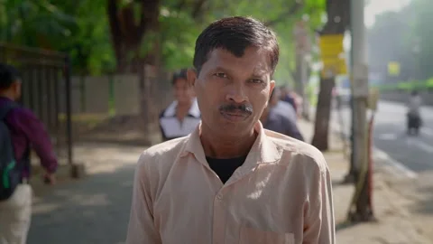 A middle aged Indian man standing outdoors and smiling facing the camera Video stock 324584249