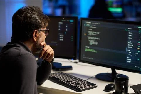 Middle Aged Indian Programmer Analyzing Cybersecurity Code on Computer Stock Photos