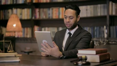 Middle Aged Lawyer Doing Video Chat on Tablet in Courtroom 動画素材 293250395