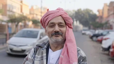 An middle aged local Indian farmer is standing outdoors looking at the camera Stock Footage 148461643