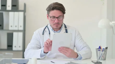 Middle Aged Male Doctor using Digital Tablet 스톡 동영상 143565656