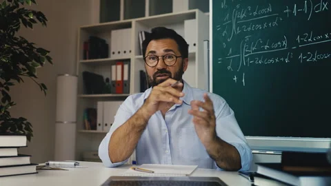 Middle-aged male math tutor conducting virtual class, online education session Stock Footage 311461856
