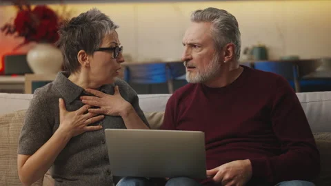 Middle-aged man and spouse read bad news on laptop, facing financial problems Stock Footage 343607422