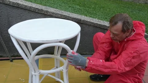 Middle aged man applying white paint on wooden tabletop with roller. Stock Footage 327654650