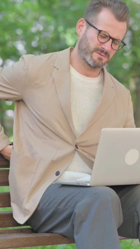 Middle Aged Man with Back Pain Using Laptop while Sitting Outdoor on Bench, Stock-Footage 319013311