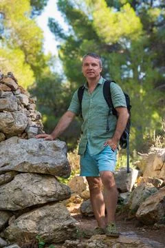 Middle aged man with backpack explores picturesque landscapes Majorca - mount Stock Photos
