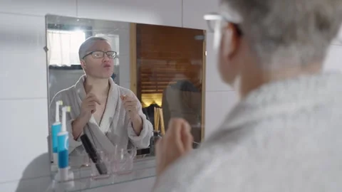 A middle-aged man in a bathrobe flossing your teeth Stock Footage 303782607