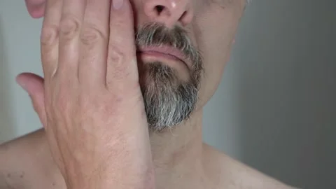 Middle aged man with beard apply face with lotion after shaving, close up 4k Stock Footage 156352506