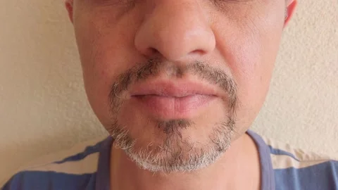 Middle-aged man with beard eats donut with chocolate icing. Portrait. Close-up. Stock Footage 133601097