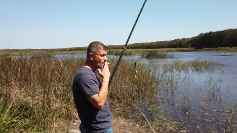 Middle-aged man with beard. guy sits in tourist chair, smokes, rests. Stock Footage 143893443