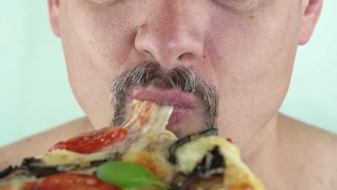 Middle aged man with beard holding in hands eating vegetarian pizza, 4K close up Stock Footage 156123933