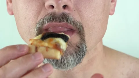 Middle aged man with beard holding in hands eating vegetarian pizza, 4K close up Stock Footage 156859188