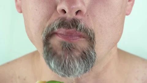 Middle aged man with beard holding in hands eating vegetarian pizza, 4K close up Stock Footage 157456391