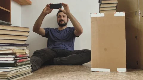 A middle-aged man with a beard speaks by video call using a smartphone while Stock Footage 160390566