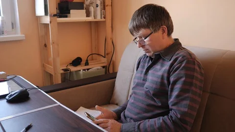 A middle-aged man behind a laptop is an online broadcast Stock Footage 129639620
