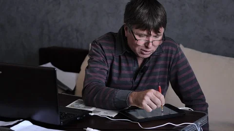A middle-aged man behind a laptop is an online broadcast Stock Footage 129894252