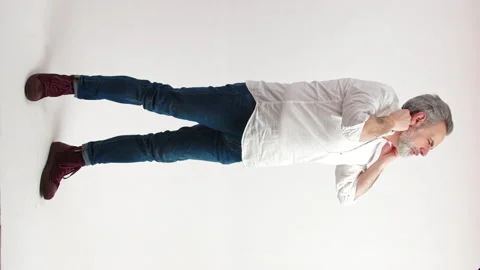 Middle aged man buttoning up his shirt and sorting out his collar - vertical 動画素材 172238613