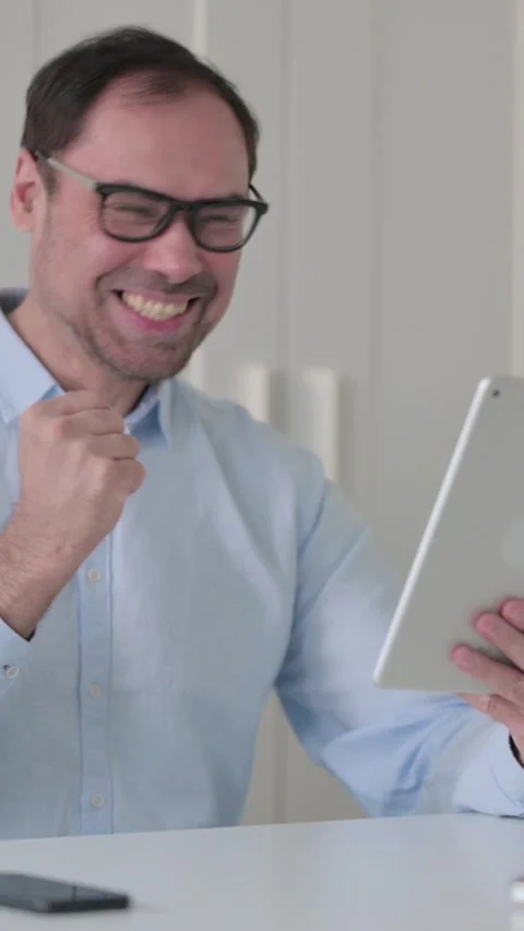 Middle Aged Man Celebrating on Tablet in Office, Vertical Video 스톡 동영상 339585088
