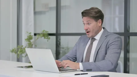 Middle Aged Man Celebrating while using Laptop in Office on Bench 스톡 동영상 162844760