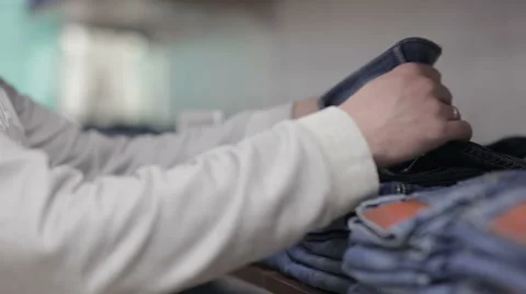 Middle-aged man chooses a jeans in store Stock Footage 60845868