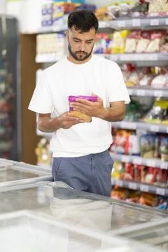 Middle-aged man choosing dried corn kernels in supermarket Stock Photos