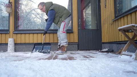 A middle-aged man is cleaning snow in the backyard Stock Footage 297868335