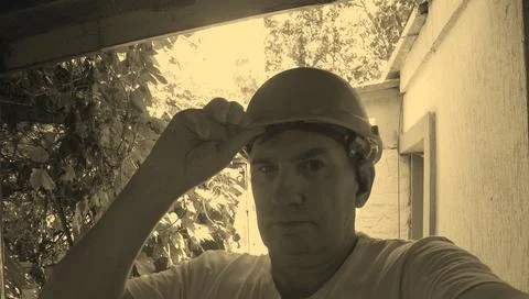 Middle-aged man in construction helmet looking forward at construction site Stock Photos