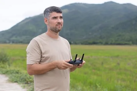 Middle aged man controls advanced tech gadgets. Drone remote control panel Stock Photos