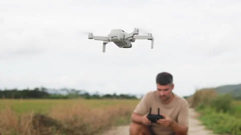 Middle aged man controls drone. It is hobby for outdoor recreation. Drone hovers Stock Footage 322565460