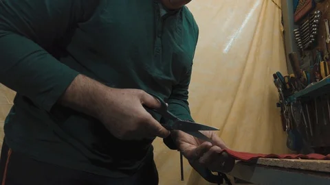 Middle-aged man cuting a red fabric for sewing. Gender equality. Closeup of male Video stock 123550878