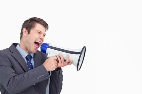 Middle-aged man in dark gray suit jacket shouting into white megaphone at Stock Photos