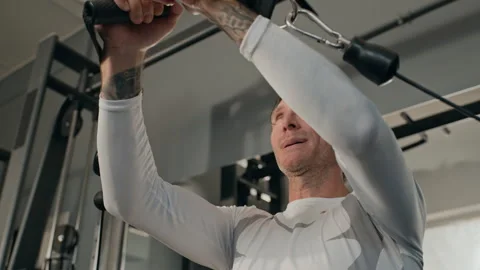 Middle Aged Man Doing Strength Training on Cable Machine in Gym Stock Footage 345200719
