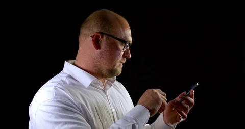 Middle aged man dressed in white shirt is holding mobile phone in hands and Stock Footage 116762295