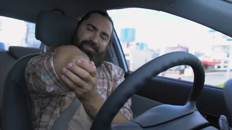 Middle-aged man driving car, suffering elbow pain, ligament sprain, injury Stock Footage 119285545
