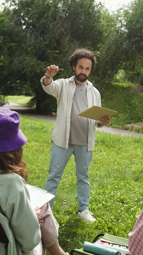 Middle Aged Man Explaining Pencil Measuring Technique in Art Class Stock Footage 341952120