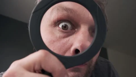 Middle-aged  man eye who is looking at the camera through a magnifying glass. Stock Footage 135943111