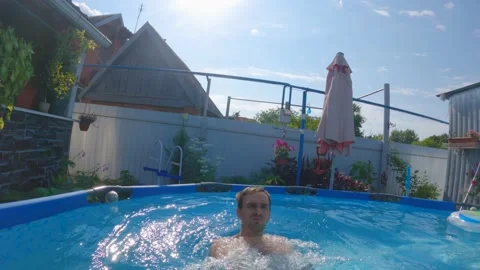A middle-aged man falls with his back to the pool. The camera follows him Stock Footage 201468632