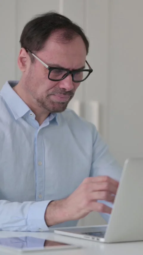 Middle Aged Man Feeling Disappointed While using Laptop in Office, Vertical 스톡 동영상 339584631