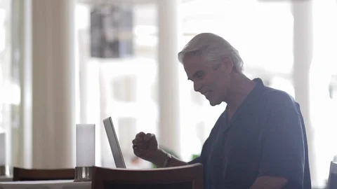 Middle-aged man fist pumping over a laptop. Stockbeeldmateriaal 88371525