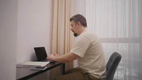 Middle aged man freelancer working from home using a laptop computer Stock Footage 340931930